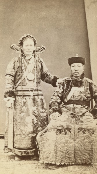 Full-length portrait of wealthy Buriat man and his wife, facing front, between 1870 and 1886. Creator: Unknown.