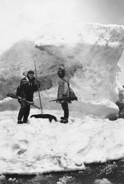 Eskimo with another man in winter scene, between c1900 and 1927. Creator: Lomen Brothers.