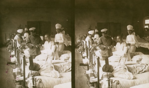 Nurses and a doctor attending wounded soldiers on a hospital ward, c1905. Creator: Underwood & Underwood.