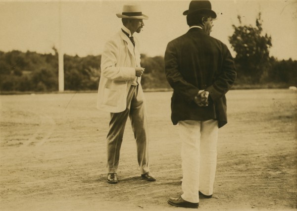 Two men, probably journalists, standing on a field, 1905. Creator: Unknown.