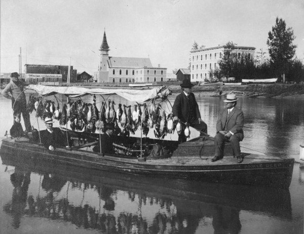 Marshall Erwin in front of a boat containing a kill of ducks, between c1900 and 1927. Creator: Unknown.