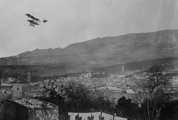 Breguet biplane, type 1910, flying over a town, possibly in Morocco, between c1910 and c1915. Creator: Bain News Service.