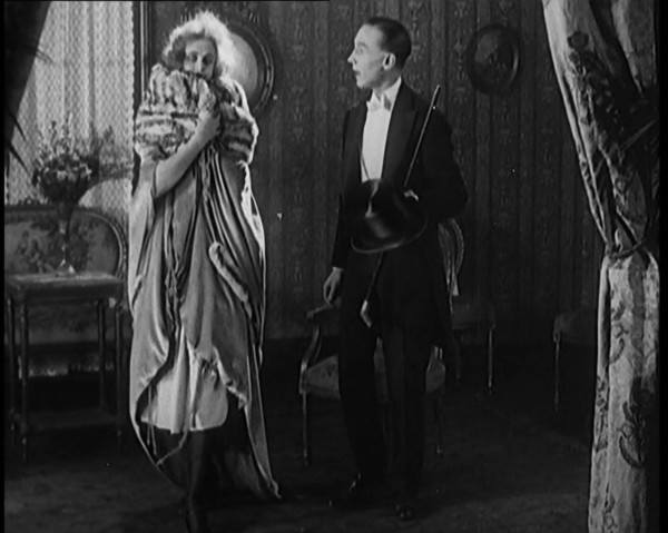 A Civilian Couple Wearing Evening Outfits Ready to Leave for an Event, the Male Holds a Top..., 1920 Creator: British Pathe Ltd.