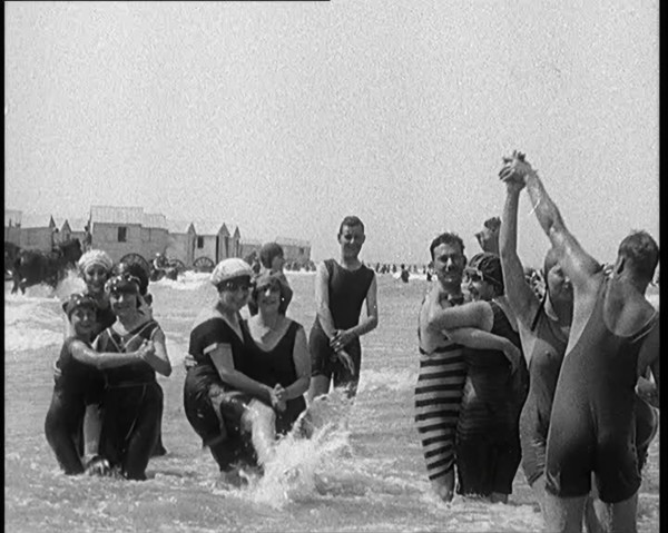Civilians Wearing Swimsuits Enjoying a Sunny Day Dancing at a Very Crowded Beach, 1920. Creator: British Pathe Ltd.