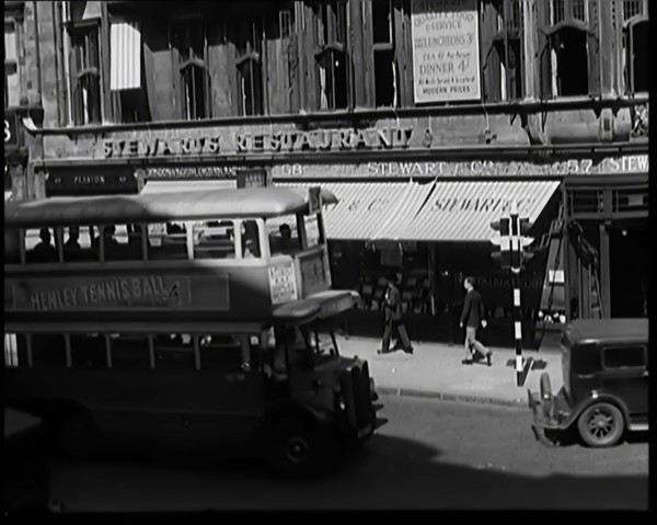 Exterior of Stewards Restaurant and London Traffic. Sign on the Side of a Bus Reads..., 1931. Creator: British Pathe Ltd.