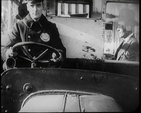 Male Bus Driver Sitting in the Cabin of a Bus, 1922. Creator: British Pathe Ltd.
