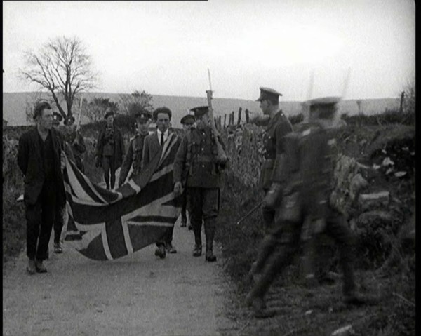 British Soldiers Marching a Sinn Fein Supporter Down a Country Lane, Forcing Him to Bear..., 1920. Creator: British Pathe Ltd.