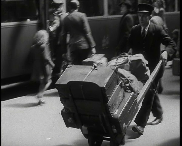 A Male Train Station Porter Pushing a Sack Barrow With Suitcases and Bags on it Along..., 1938. Creator: British Pathe Ltd.