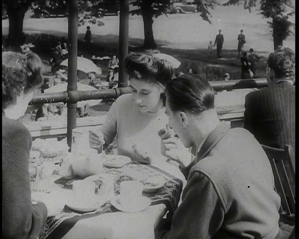 A Close up of Two Women and a Man Having Food and Drink on the Roof Terrace at  the Tea..., 1939. Creator: British Pathe Ltd.