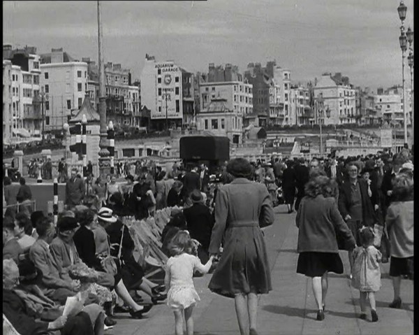 British Holidaymakers Walking Along the Promenade or Sitting on Deckchairs at Brighton..., 1938. Creator: British Pathe Ltd.
