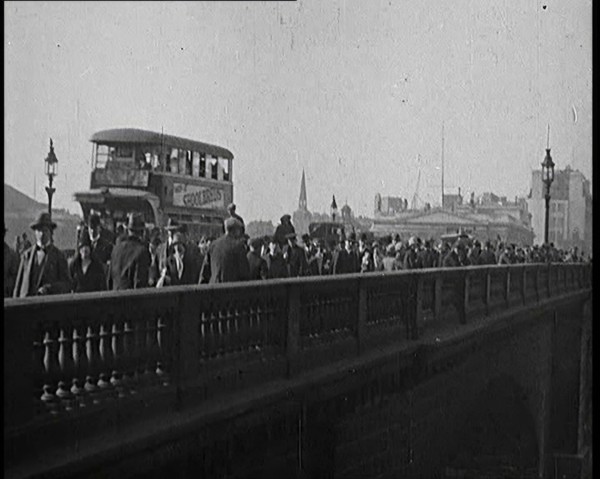 Pedestrians And Commuters Crossing London Bridge With Buses in the Background, 1920s. Creator: British Pathe Ltd.