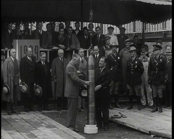Two British Men Guiding a Time Capsule Being Lowered in the Ground With Various Civilians..., 1938. Creator: British Pathe Ltd.