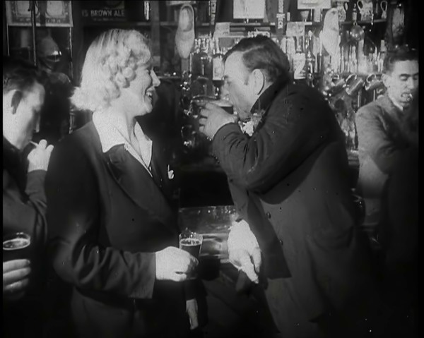 A British Woman and a British Man Standing at  the Bar Holding Drinks in a Public House..., 1939. Creator: British Pathe Ltd.