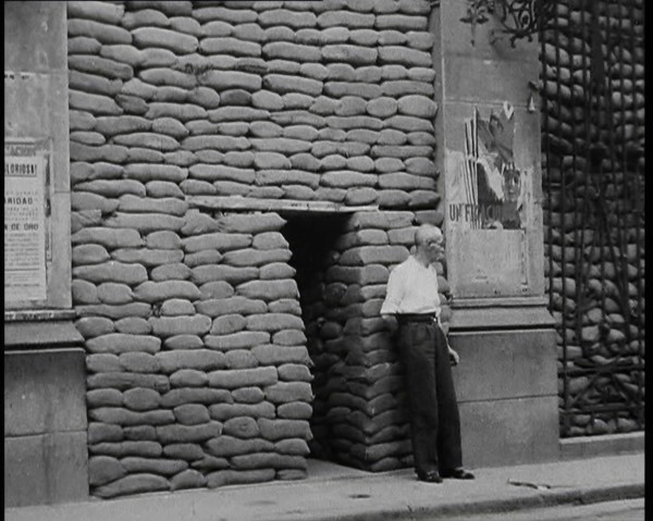A Man Standing Outside the Frontage of a Building Obscured By Sandbags Next To an..., 1937. Creator: British Pathe Ltd.