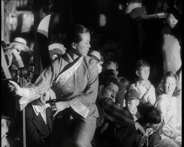 A Female Civilian in a Traditional Robe Dancing With Sabres As People Watch Her Performanc..., 1932. Creator: British Pathe Ltd.