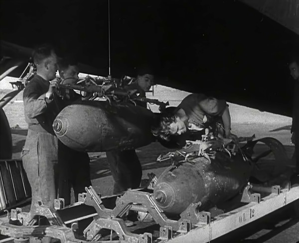 RAF Ground Crew Members Fixing Bombs to an Avro Lancaster Bomber, 1942. Creator: British Pathe Ltd.