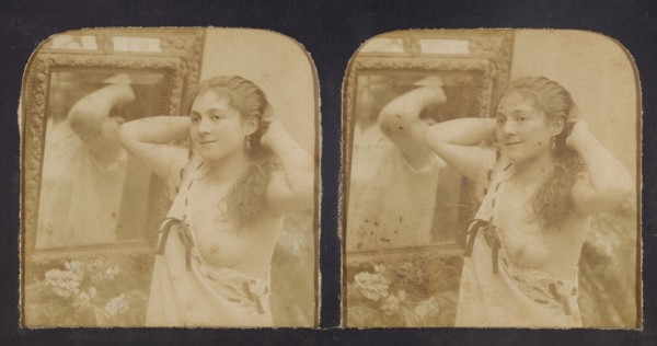 Woman before mirror with hands behind head, one breast exposed, 1855-1860. Creator: Unknown.