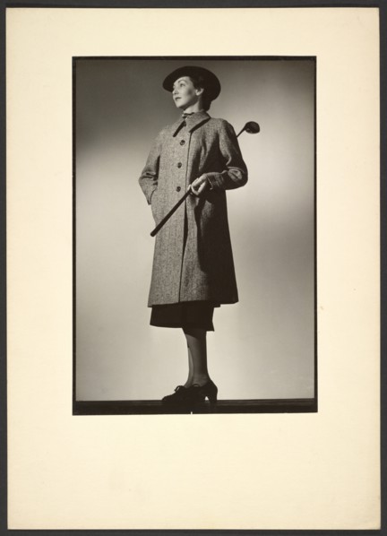 Woman modeling coat with golf club, early 1940s. Creator: Gunther Krampf.