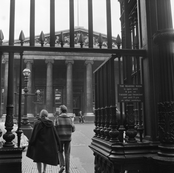 Visitors around the wrought iron gates at the south entrance to the British Museum, London,