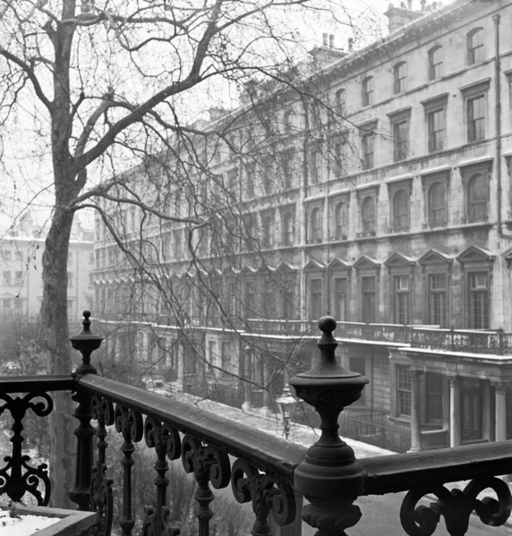 Looking along the side of a lightly-snowy London square from a raised position behind a