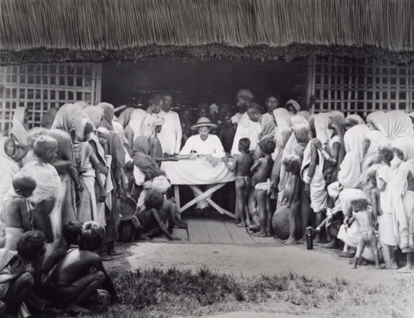 Paying wages to tea estate labourers, Bengal, 1880s. A European distributes pay to Indian workers,