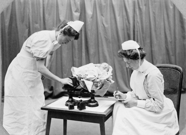 General Lying In Hospital, York Road, Lambeth: nurses weighing a baby, 1908. Creator: Unknown.