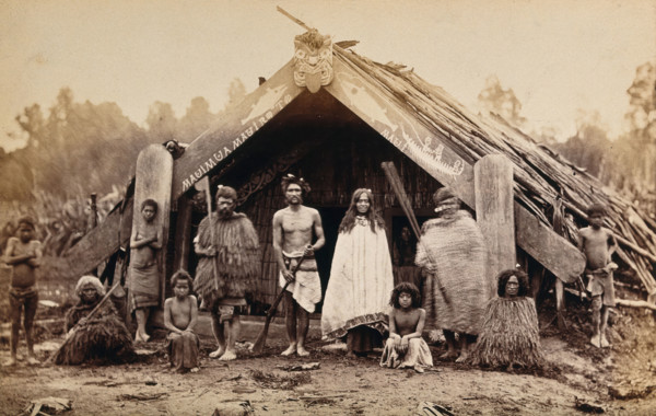 New Zealand: a group of Maori in front of a traditional building, 19th century. Creator: Unknown.