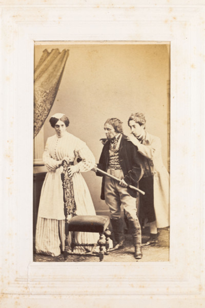 Three men, one in drag, acting out a scene, [between 1890 and 1899?]. Creator: Unknown.