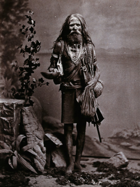 An Indian man wearing many beads, and carrying a begging bowl and an umbrella, in a..., c1900. Creator: Unknown.