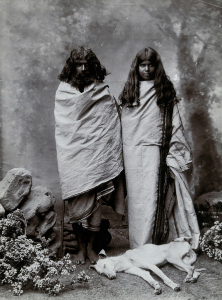 A man and woman of the Toda tribe standing in a photographic studio, with a dog lying..., c1900. Creator: Unknown.