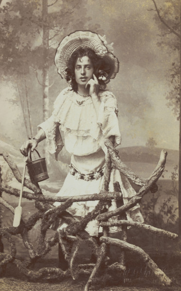 A sailor in drag posed behind a wooden fence, 1906. Creator: Unknown.