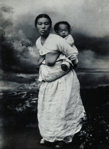 A Korean (?) woman, carrying a baby on her back, approx 1900. Creator: Unknown.
