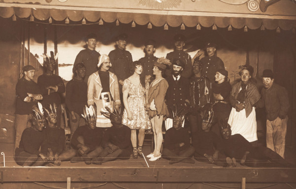 Soldiers, some in drag, pose on stage; two men in drag face each other in the centre, [1910-1919?]. Creator: Unknown.