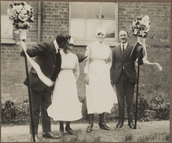 Two men holding tutti poles, with two women during the Hocktide Festival in Hungerford, 1925-35.  Creator: George R Long.