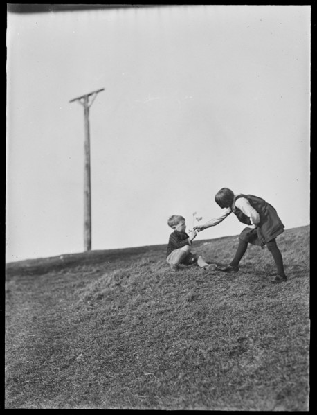 Two children playing in front of Combe Gibbet, Inkpen Hill, Inkpen, West Berkshire, 1925-1935. Creator: George R Long.