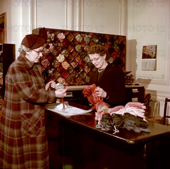 Choosing wools at the shop counter, Royal School of Needlework, c1955. Creator: Arthur Charles Kirby Ware.