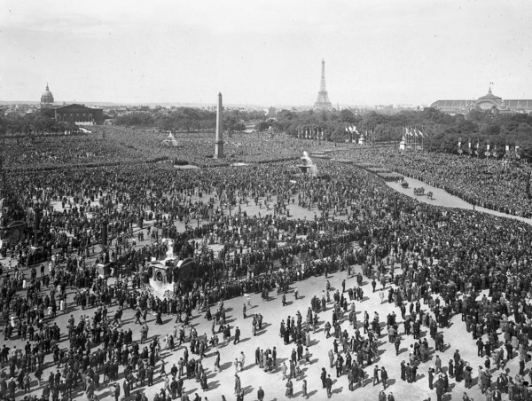 Dans les années 1930 à Paris, foule et défilé militaire du 14 juillet sur la place de la Concorde.