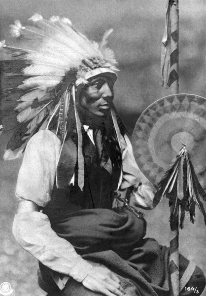 Carte photo représentant  un jeune indien assis