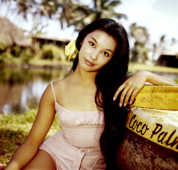 France NUYEN leaning against a boat