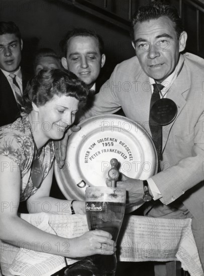 Peter FRANKENFELD taps beer from a beer keg, 1959