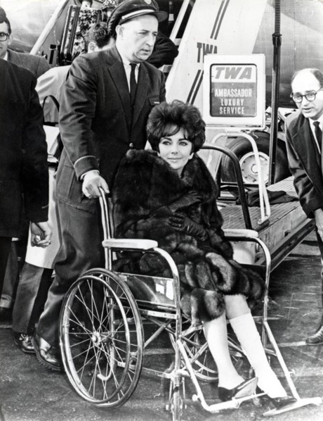 Elizabeth TAYLOR in a wheelchair, 1961