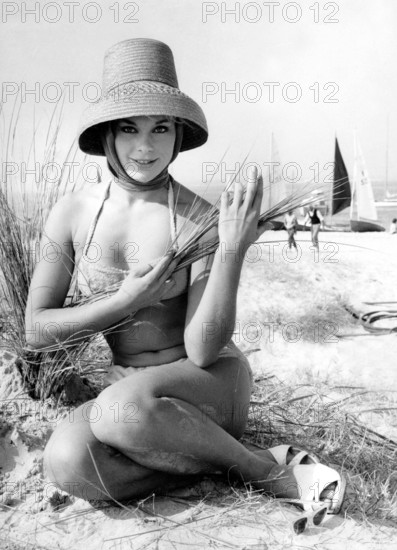 Elke SOMMER in a bikini with a straw hat on the beach in 1960