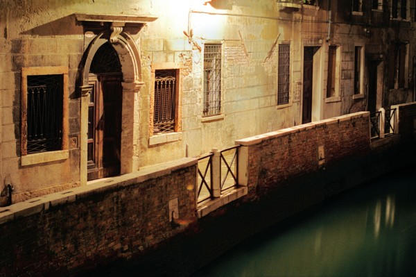 Passage éclairé et bord de canal de nuit