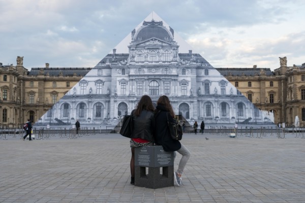 Louvre museum pyramid covered with thousands of paper sheets to make it disappear with an optical illusion.