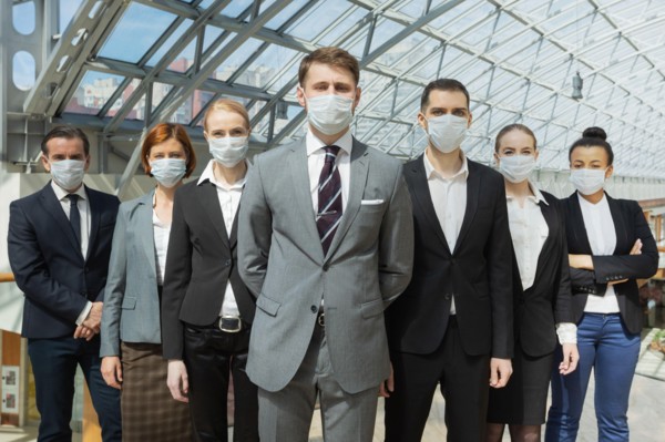 Business people wearing surgical protective masks and standing together, healthcare and covid-19 prevention concept