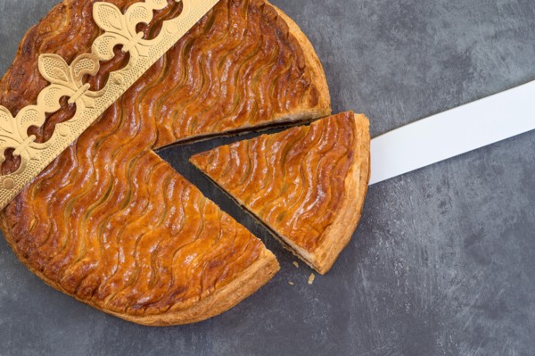 Galette des rois, french kingcake with a golden crown on a grey slate background