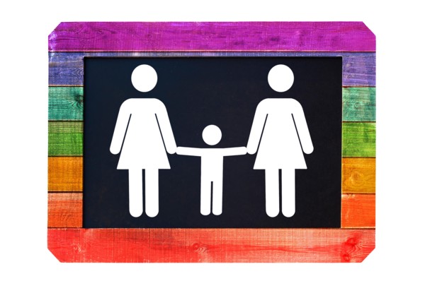 Lesbian family with child white sign on a blackboard, rainbow gay flag colors