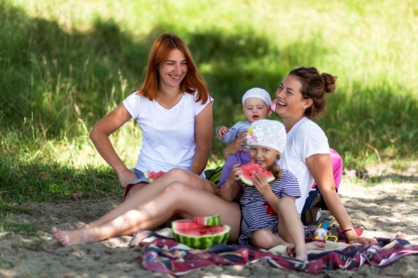 Concept for togetherness and bright future.Two beautiful women with a baby on the picnic  in park at  during vacation  Couple lovers woman smile and e