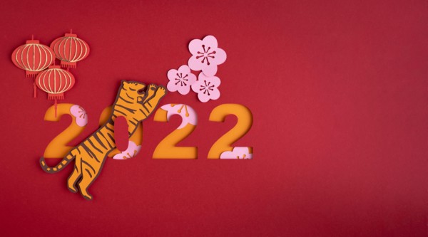 Chinese New Year. Decoration with traditional Chinese New Year motifs, cut out paper decorations on red cardboard background. Copy space.