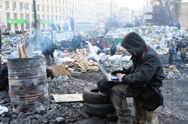 Kiev, Ukraine. 02nd Feb, 2014. A man sits with a laptop near to a fire at the so-called EuroMaidan demonstrations that began after plans for closer integration with Europe were scrapped in November 20...